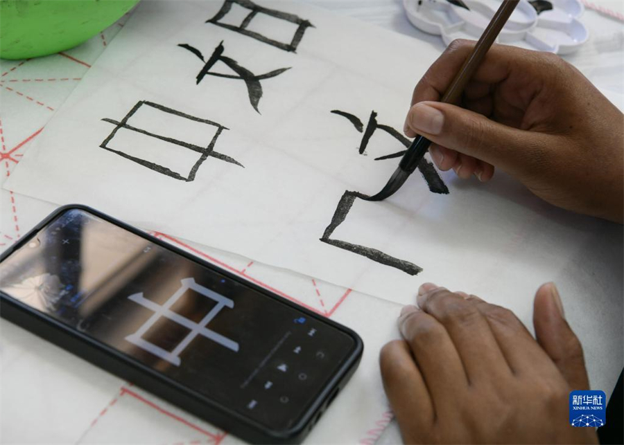 4月18日，肯尼亞學(xué)生在內(nèi)羅畢大學(xué)孔子學(xué)院舉辦的活動(dòng)上寫毛筆字?？夏醽唭?nèi)羅畢大學(xué)孔子學(xué)院18日舉辦“中文，增進(jìn)文明對(duì)話”主題活動(dòng)，慶祝即將到來(lái)的第14個(gè)聯(lián)合國(guó)中文日?？夏醽唽W(xué)生參與互動(dòng)，進(jìn)行書法、剪紙、唱中文歌等活動(dòng)。新華社記者 韓旭 攝