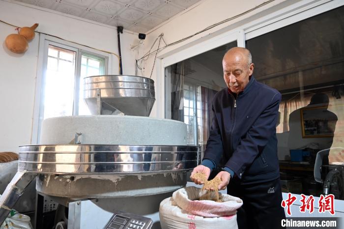 李家莊村民谷文朝重拾父輩的手藝，做起石磨面粉的營(yíng)生?！〉杂鸺?攝