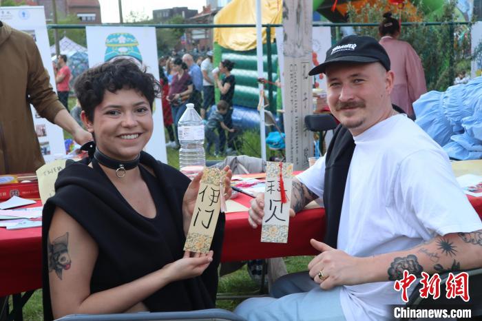 當(dāng)?shù)孛癖娫跐h字體驗(yàn)工作坊展示自己手寫的中文名書簽?！◆斻肟鬃訉W(xué)院供圖