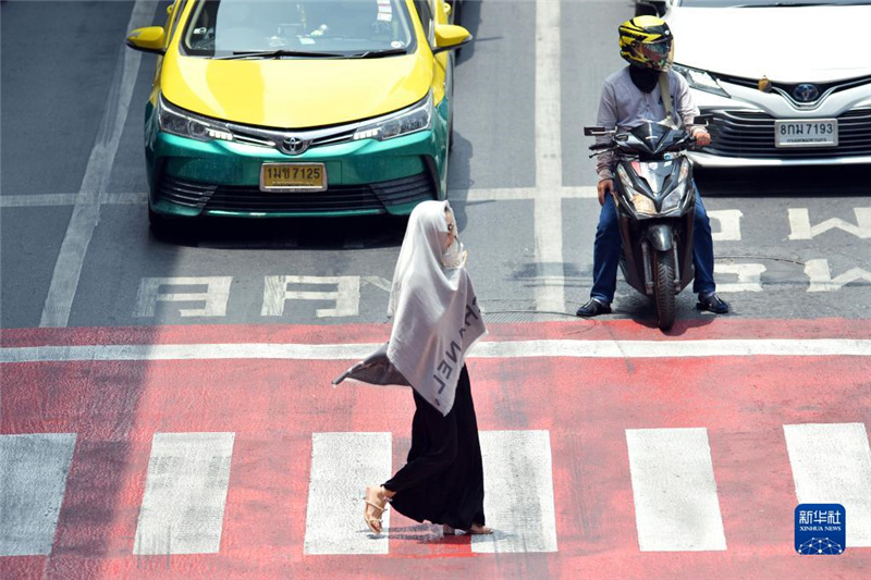 5月17日，行人在泰國(guó)曼谷街頭用圍巾遮陽(yáng)。新華社發(fā)（拉亨攝）