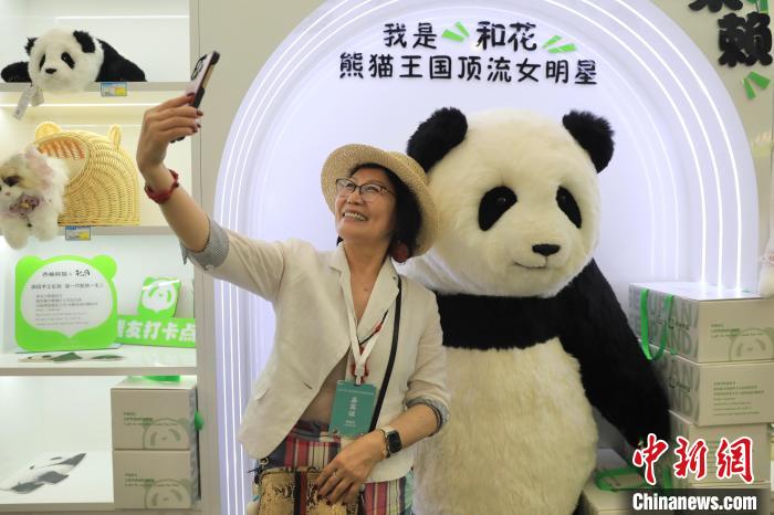 美國華視總裁楊蓮花與大熊貓文創(chuàng)產(chǎn)品合影?！⊥趵?攝