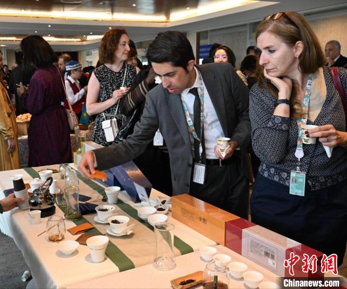 現(xiàn)場觀眾觀看中國展臺(tái)茶藝表演、了解茶文化。　靖樹 攝
