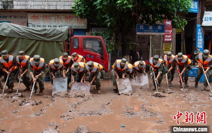 7月4日，萬州區(qū)五橋街道，武警官兵清理街道上的淤泥?！∪矫宪?攝