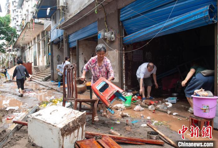 7月4日，萬州區(qū)五橋街道，洪水退去后，居民搶救生活物資?！∪矫宪?攝
