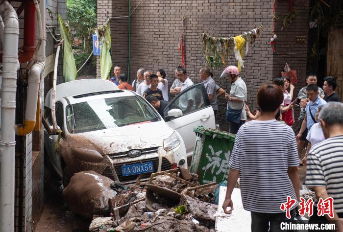 7月4日，萬州區(qū)五橋街道，居民救援受困的私家車。　冉孟軍 攝