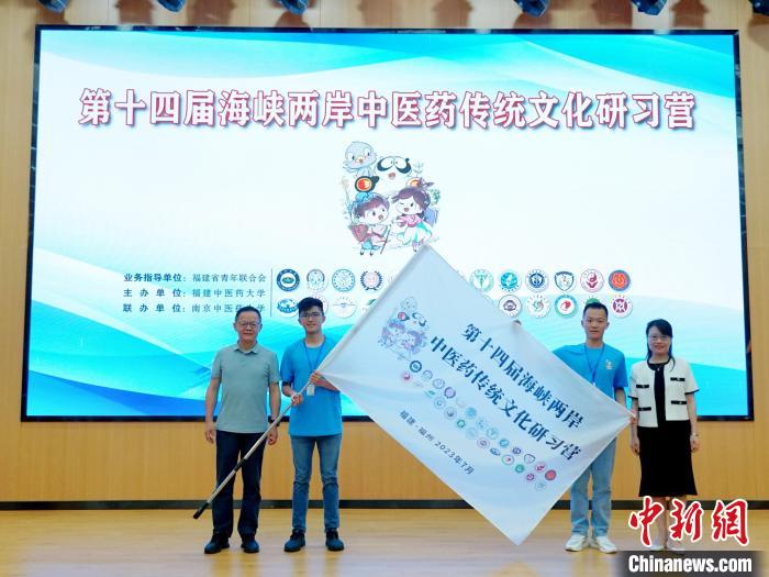 共青團福建省委副書記吳雪(右一)、福建中醫(yī)藥大學黨委副書記林羽(左一)為兩岸學生代表頒授營旗?！≡S燁婷 攝