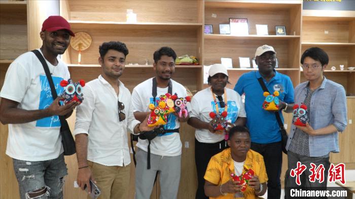 圖為國(guó)際青年代表展示親手制作的東營(yíng)非遺黃河口布偶 。　齊魯 攝