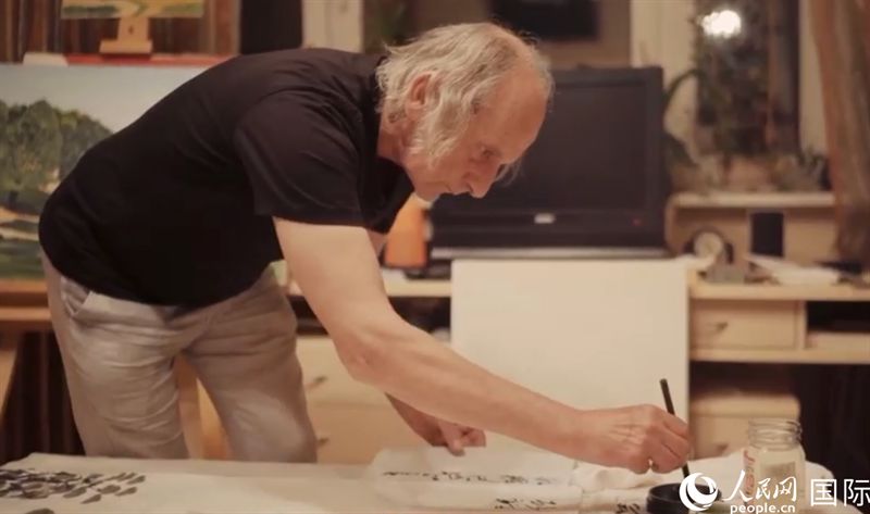 伊戈?duì)枴げ紶枛|諾夫在畫(huà)作上題詞。人民網(wǎng)記者 馬天翼攝