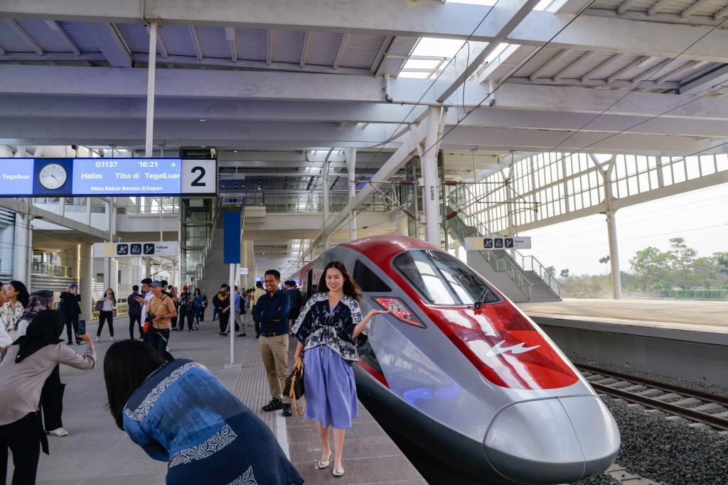 10月17日，在印度尼西亞萬隆德卡魯爾站，乘客在站臺上和雅萬高鐵高速動車組列車合影。