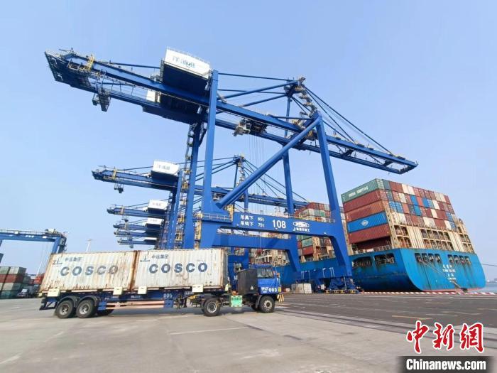圖為海南洋浦國際集裝箱碼頭，卡車將集裝箱從后方堆場運(yùn)往碼頭裝卸區(qū)。　張月和 攝