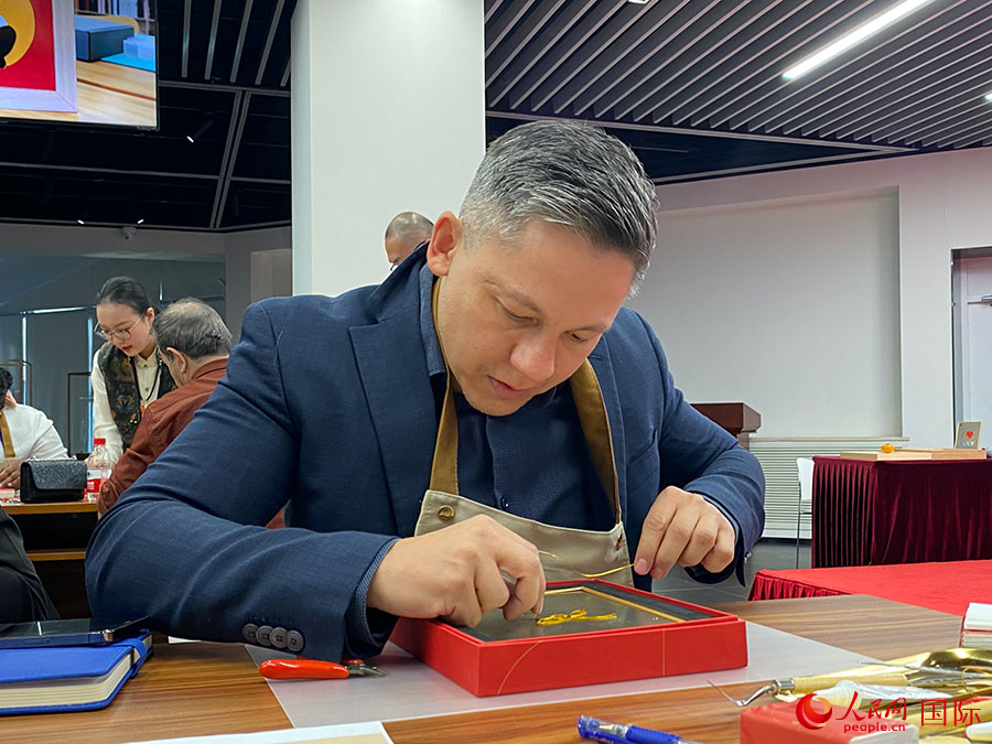 2023“一帶一路”媒體合作論壇聯(lián)合采訪團(tuán)團(tuán)員，親身體驗(yàn)景泰藍(lán)工藝。人民網(wǎng)記者 于洋攝