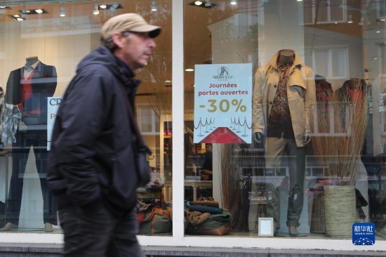   10月31日，一名男子從比利時(shí)布魯塞爾一家貼有打折信息的店鋪前走過。新華社記者 趙丁喆 攝