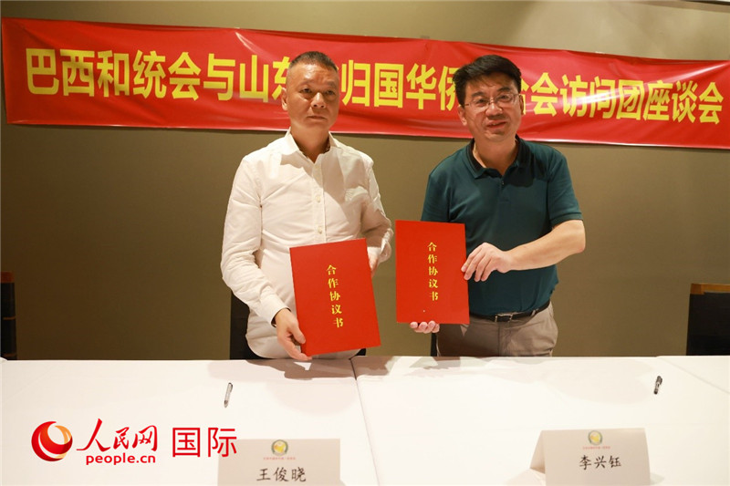 中國僑聯(lián)副主席、山東省僑聯(lián)主席李興鈺（右）與巴西和統(tǒng)會會長王俊曉簽署合作協(xié)議書。人民網(wǎng)記者 陳海琪攝