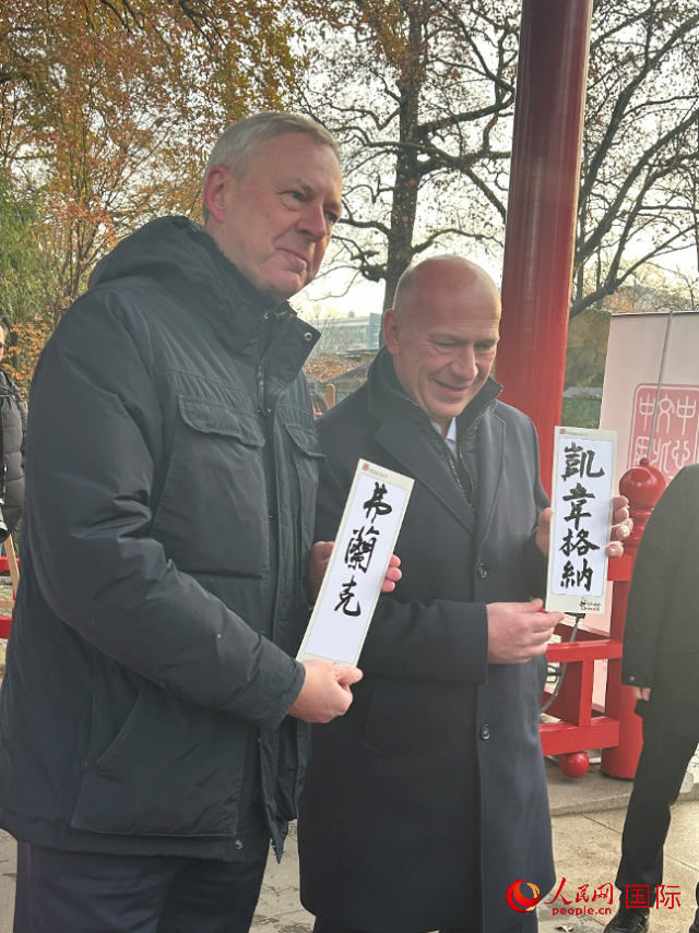 柏林市長韋格納（右）、動物園監(jiān)事會主席布魯克曼（左）手持中國文化中心工作人員現(xiàn)場手書的中文名字。人民網(wǎng)記者 徐馨攝