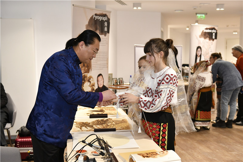 圖為羅馬尼亞小學(xué)生在現(xiàn)場體驗(yàn)烙畫。 布加勒斯特中國文化中心供圖