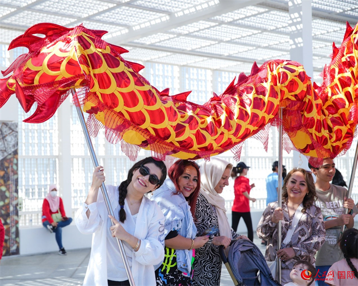 游客體驗舞龍。 人民網(wǎng) 塔里克·易卜拉欣攝