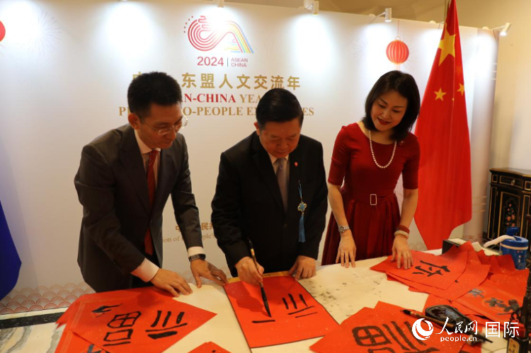 東盟秘書(shū)長(zhǎng)高金洪（中）在活動(dòng)現(xiàn)場(chǎng)寫(xiě)福字。人民網(wǎng)記者曹師韻攝