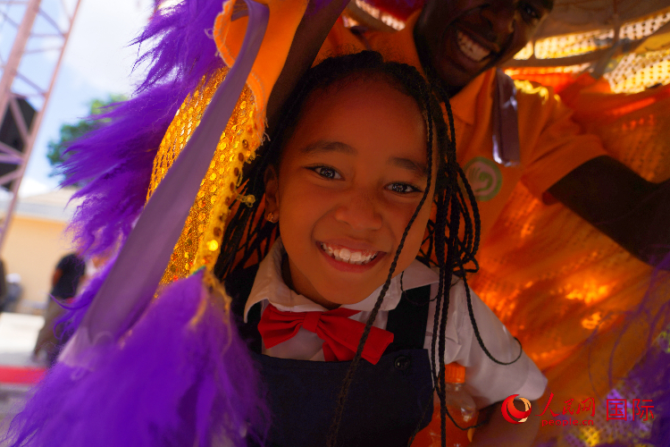 一名小朋友在與舞獅表演者互動。人民網(wǎng)記者 黃煒鑫攝