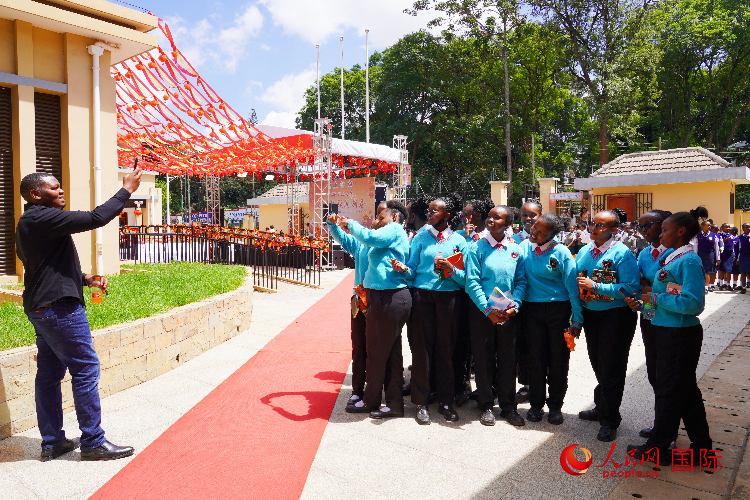 一名老師在給學(xué)生拍照留念。人民網(wǎng)記者 黃煒鑫攝