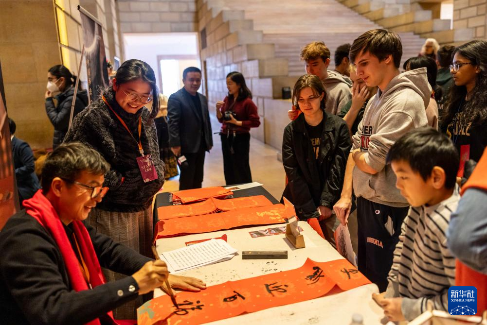 2月11日，書法家在美國費城藝術(shù)博物館舉行的龍年迎新春活動上為參觀者書寫對聯(lián)。新華社發(fā)（周煥新攝）