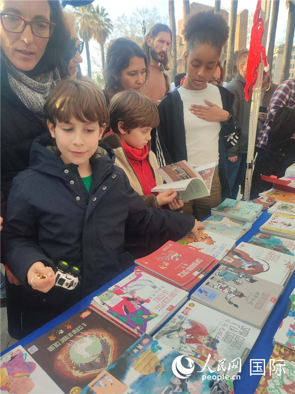 印刷精美的中國傳統(tǒng)文化叢書吸引了小游客的注意。人民網(wǎng)記者鄭彬攝