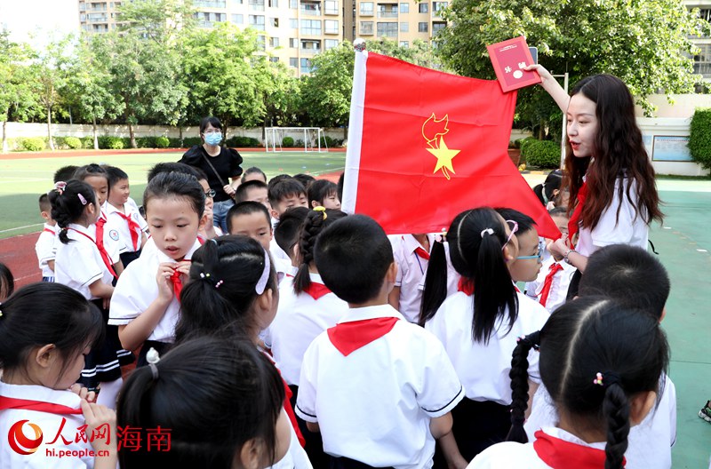 老師向少先隊員展示隊旗。人民網(wǎng) 符武平攝