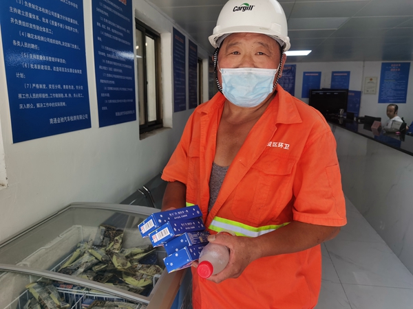 1環(huán)衛(wèi)工倪建宏小憩后，為還同事帶去冷飲。人民網(wǎng)記者王繼亮攝