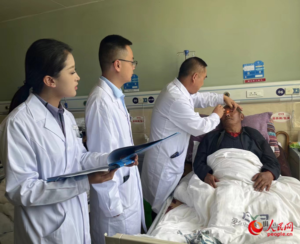 董光明（左三）帶領(lǐng)醫(yī)生對(duì)患者進(jìn)行術(shù)前檢查。人民網(wǎng)記者 杜燕飛攝