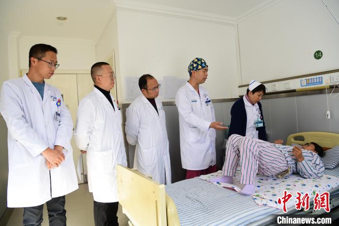 圖為何蔚副主任醫(yī)師(站右二)及團隊術(shù)后指導(dǎo)患者進行腰背肌鍛煉?！∝暩聛硭?攝