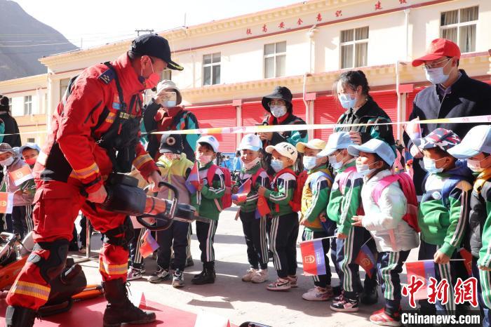 圖為消防指戰(zhàn)員為學生講解、演示先進救援裝備。　趙琳 攝