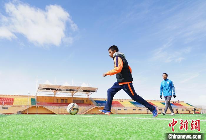 圖為一名男孩運(yùn)球射門。　馬銘言 攝