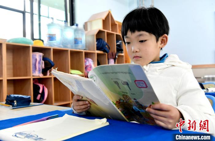 3月14日，西藏拉薩市第一小學(xué)一年級(jí)六班學(xué)生丁增樂吉在閱讀藏語課本?！±盍?攝