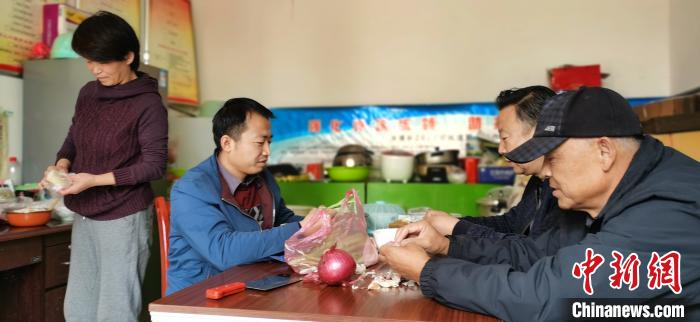 圖為扶貧路上“臨時(shí)一家人”準(zhǔn)備午餐?！∥航ㄜ?攝