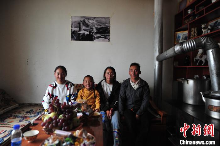 圖為8月12日，2018年7月從距那曲市色尼區(qū)城區(qū)那曲鎮(zhèn)90千米外的古露鎮(zhèn)當(dāng)桑村搬遷至城區(qū)的旦增(右一)與家人在80多平方米的新家合影(資料圖)?！垈?攝