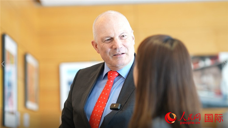 瑞士駐華大使白瑞誼介紹使館內(nèi)陳列的照片。人民網(wǎng) 彭昱凱攝