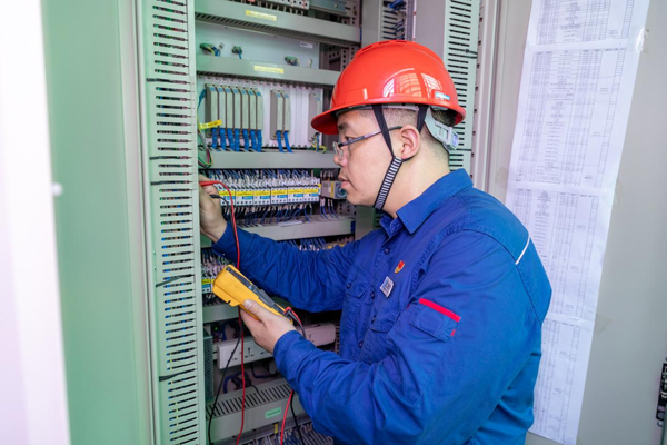 呂曉勇在保護(hù)盤柜前檢查二次回路接線情況。受訪者供圖