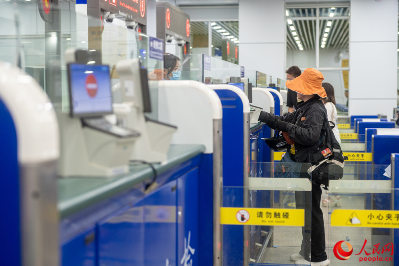 越南游客正在辦理入境手續(xù)。人民網(wǎng)記者 嚴(yán)立政攝