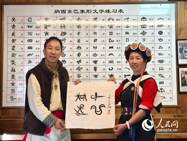 人民網(wǎng)“行進(jìn)中國”云南調(diào)研采訪團(tuán)走進(jìn)麗江，和閏元現(xiàn)場(chǎng)用東巴文寫下“行進(jìn)中國”。人民網(wǎng)記者 符皓攝