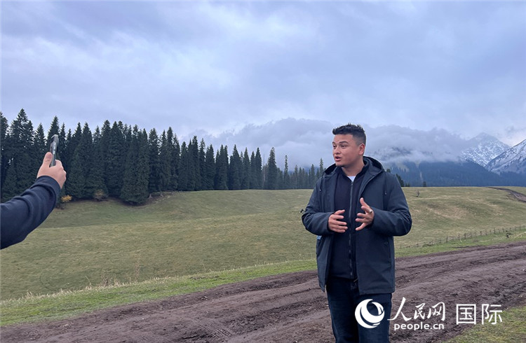 在庫爾德寧，吾買爾江被雪山美景震撼，即興錄制了短視頻作品。人民網(wǎng)記者曾書柔攝