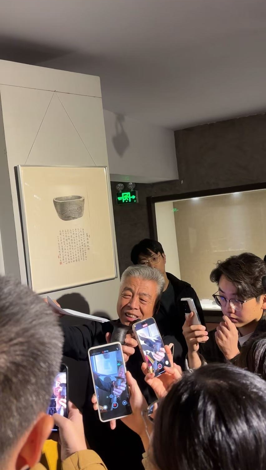 黑陶邢文化博物館館長邢葆東展示兩張相疊的A4紙，向記者解釋此為杯口的厚度。