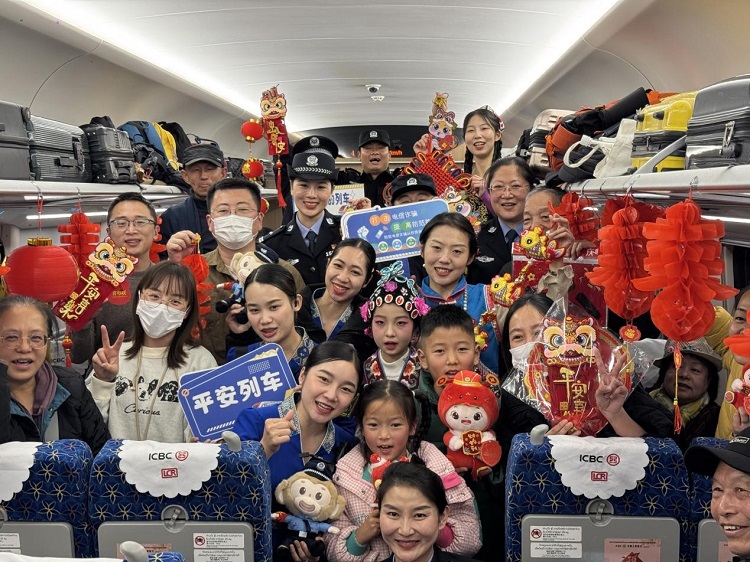 春節(jié)期間，在中老鐵路磨萬（磨丁—萬象）段，鐵路客運員工與乘客合影留念。李加勇攝