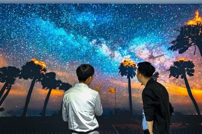 長春光博會希達電子展區(qū)，一位工作人員正在給一位觀眾講解。（長春新區(qū)供圖）