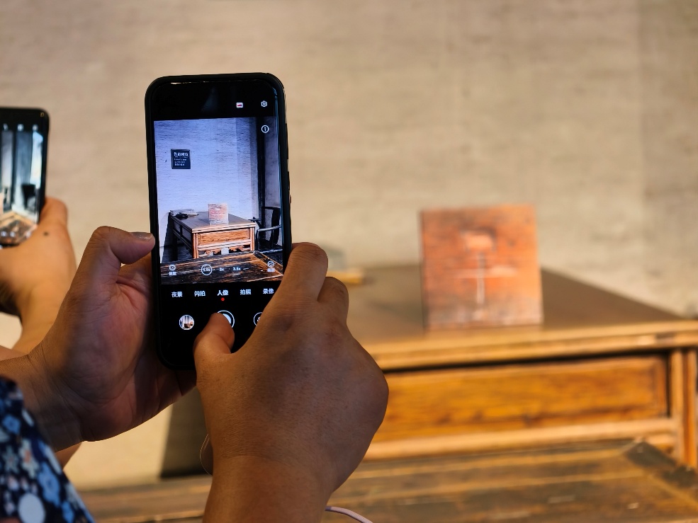 2025年7月15日，暑期研學(xué)團(tuán)小朋友在浙江省紹興市三味書屋拍攝魯迅讀書座位及課桌上的“早”字。受訪者供圖