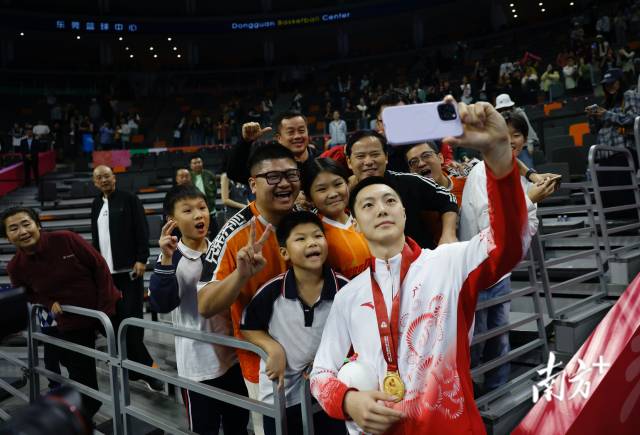 11月12日，十五運(yùn)會(huì)男籃成年組決賽，廣東隊(duì)獲得冠軍后，胡明軒與球迷們合影留念。張由瓊 攝