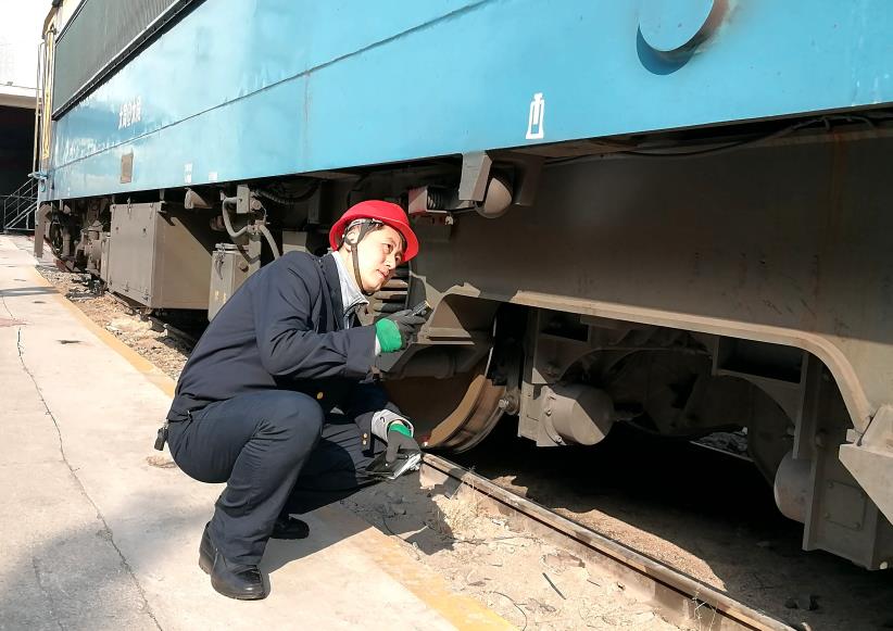 韓文盛全神貫注檢查機(jī)車(chē)走行部。