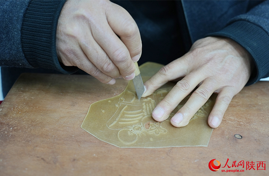 陳義文正在進(jìn)行雕刻皮影。人民網(wǎng)記者 孫挺攝