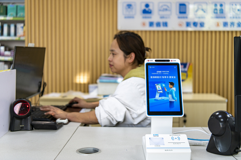 2024年4月10日，浙江金華市區(qū)一家民眾大藥房柜臺(tái)上設(shè)置著醫(yī)?！八⒛樦Ц丁睓C(jī)器，群眾看病更加便利。