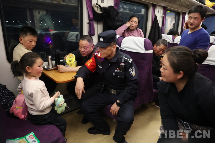 乘警長左紅彬在巡視車廂間隙，向攜帶兒童的旅客專門叮囑安全注意事項(xiàng)。.JPG