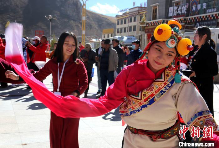 圖為中外記者向當(dāng)?shù)孛癖妼W(xué)習(xí)民族歌舞文化?！?zhí)砀?攝