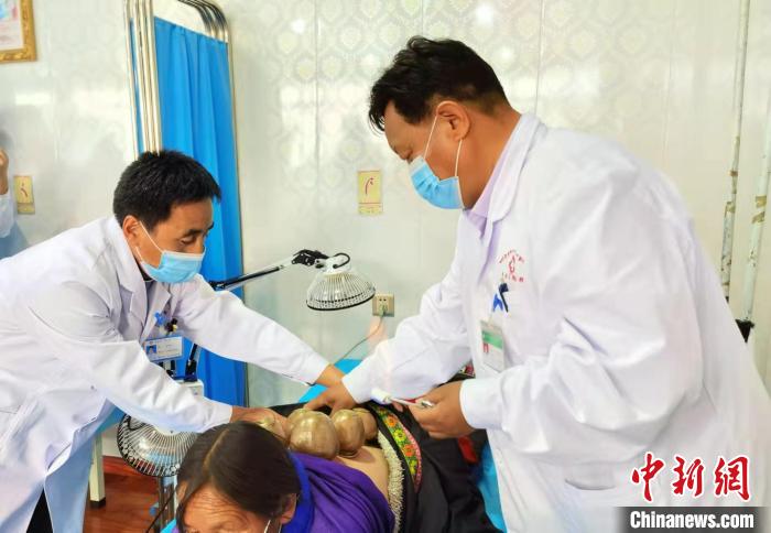 圖為看照加手把手帶徒弟加老(左一)進行拔罐療法?！堟?攝